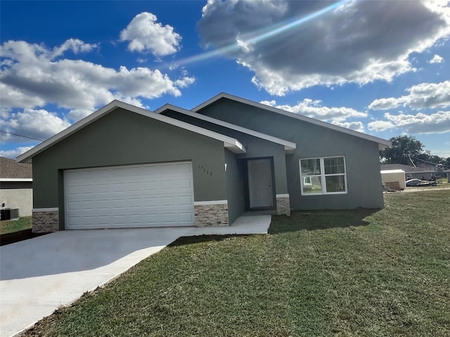 view of front of property featuring a front lawn, central air condition unit, and a garage