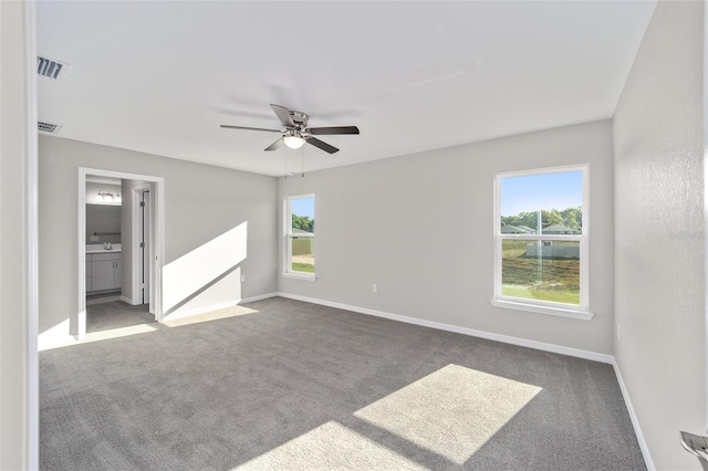 empty room featuring ceiling fan, sink, and dark carpet