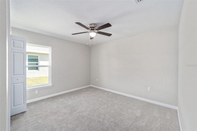 carpeted spare room featuring ceiling fan