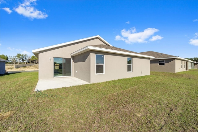 rear view of property featuring a patio area and a yard