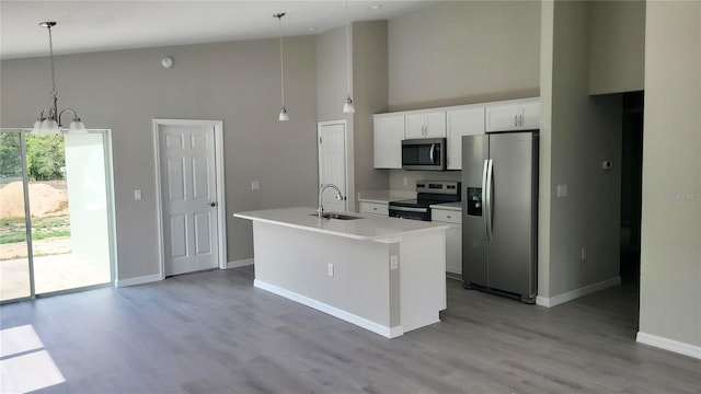 24300 SW Sea Cliff Ave, Dunnellon, FL 34431 - kitchen featuring stainless steel appliances, high vaulted ceiling, a center island with sink, light countertops, and white cabinetry
