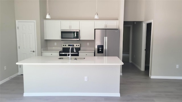 24300 SW Sea Cliff Ave, Dunnellon, FL 34431 - kitchen featuring appliances with stainless steel finishes, a center island with sink, white cabinetry, light countertops, and a high ceiling