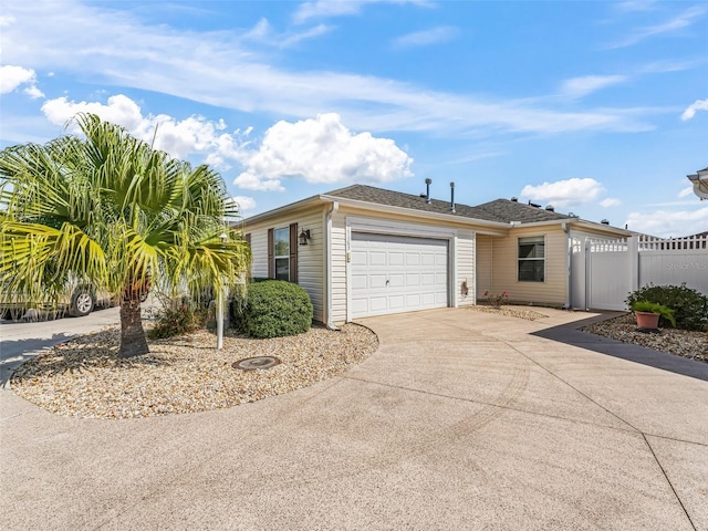 view of front facade featuring a garage, driveway, and fence