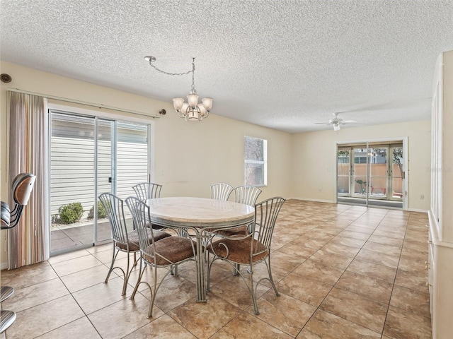 dining room featuring baseboards, light tile patterned flooring, a textured ceiling, and ceiling fan with notable chandelier