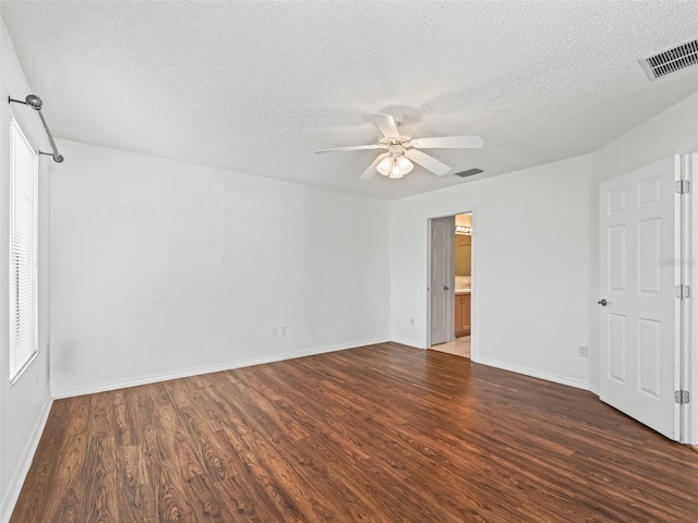 spare room with visible vents, ceiling fan, and wood finished floors