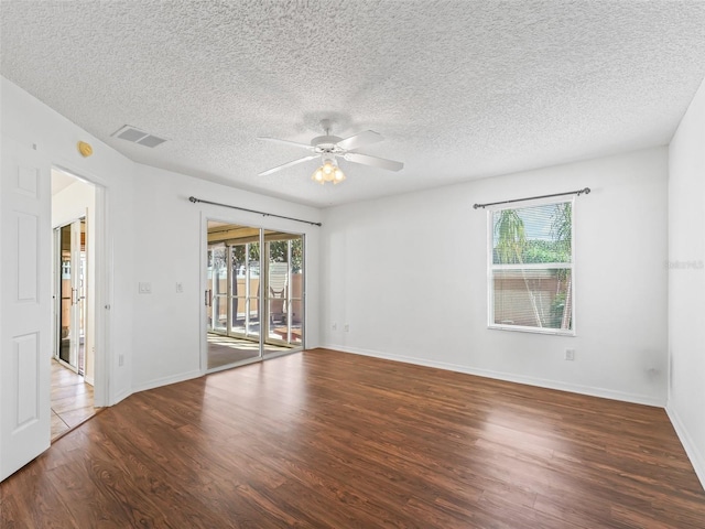 spare room with ceiling fan, a textured ceiling, visible vents, and wood finished floors