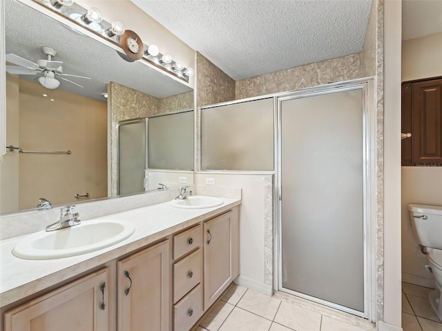 bathroom featuring tile patterned flooring, a sink, a textured ceiling, and toilet