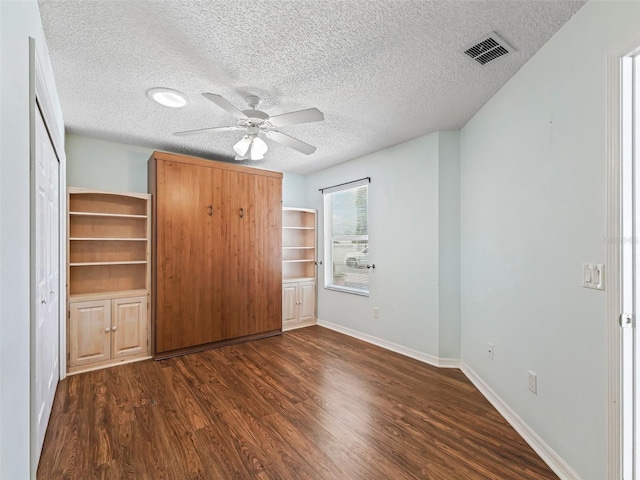 unfurnished bedroom with baseboards, visible vents, a ceiling fan, wood finished floors, and a textured ceiling