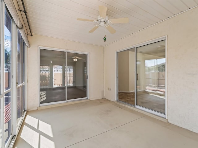 unfurnished sunroom with ceiling fan