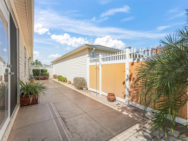 view of side of property featuring a patio and fence