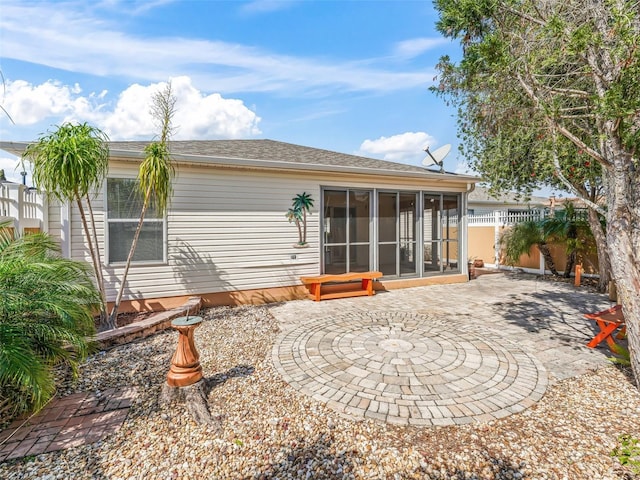 rear view of property with a patio area, fence, and a sunroom