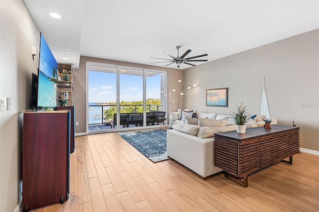 living room featuring ceiling fan and light wood-type flooring