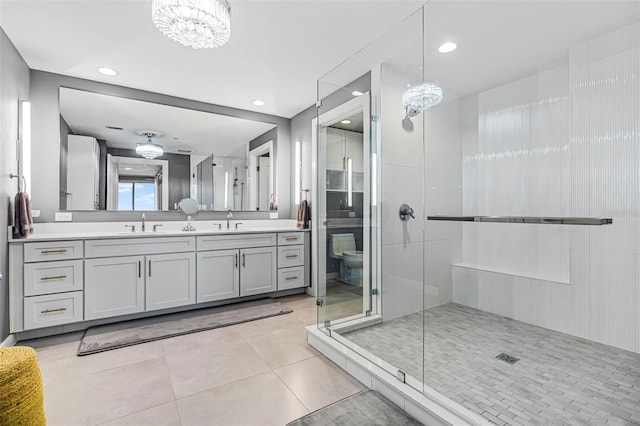 bathroom with a notable chandelier, tile patterned floors, an enclosed shower, toilet, and vanity