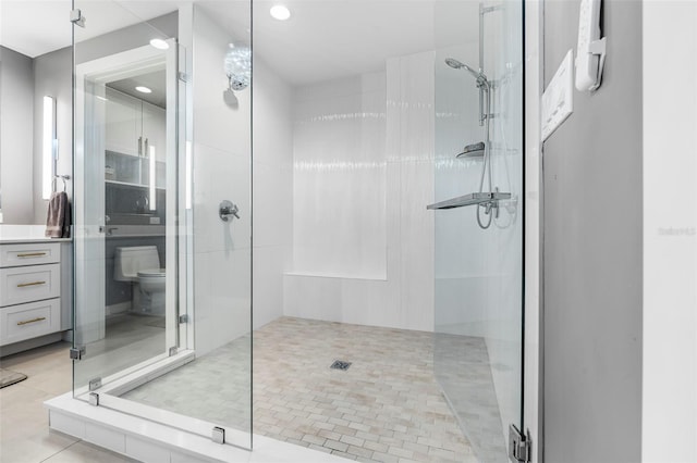 bathroom featuring tile patterned floors, toilet, and walk in shower