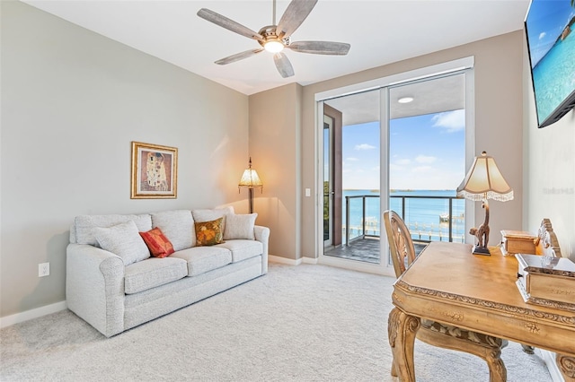 carpeted office space featuring ceiling fan and a water view