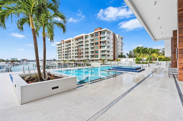 view of pool featuring a water view and a patio area