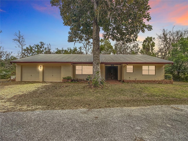 ranch-style house featuring a yard and a garage