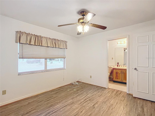 unfurnished bedroom with sink, ensuite bath, ceiling fan, and light wood-type flooring