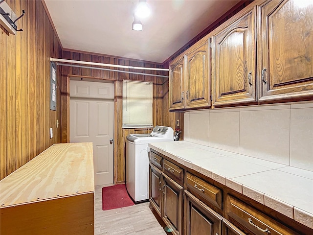 washroom featuring light hardwood / wood-style flooring, cabinets, and washing machine and clothes dryer