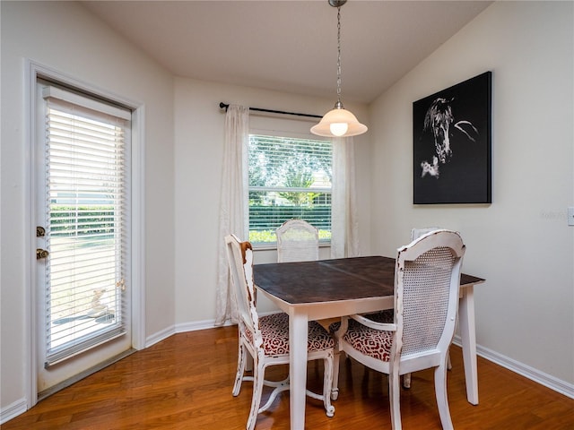 dining space with plenty of natural light, hardwood / wood-style floors, and lofted ceiling