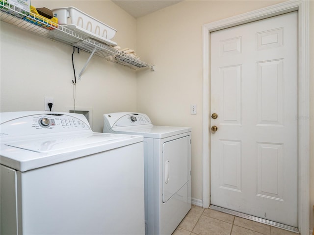 laundry area featuring separate washer and dryer and light tile patterned floors