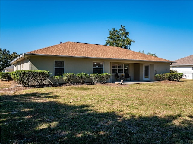 back of property featuring a lawn and a patio