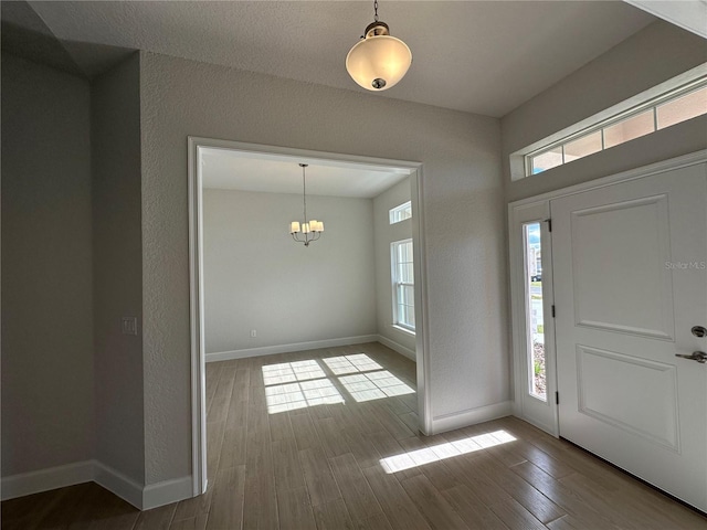 entryway featuring hardwood / wood-style flooring and an inviting chandelier