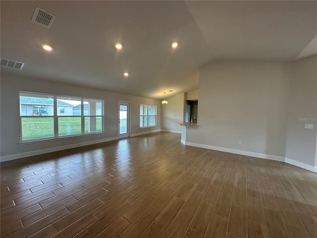 unfurnished living room featuring an inviting chandelier and lofted ceiling