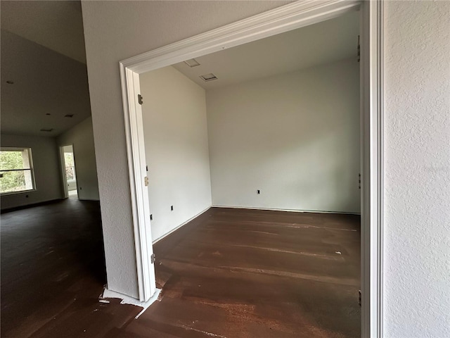 empty room featuring dark hardwood / wood-style flooring and vaulted ceiling