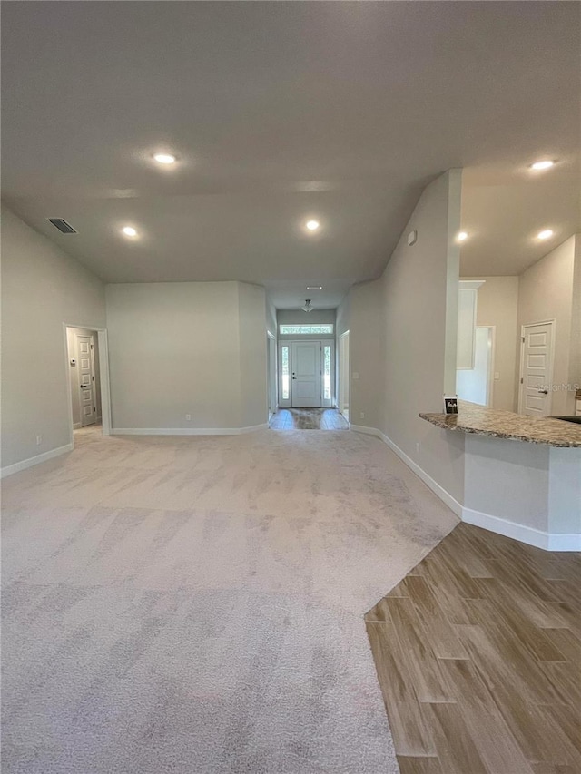 unfurnished living room with light colored carpet