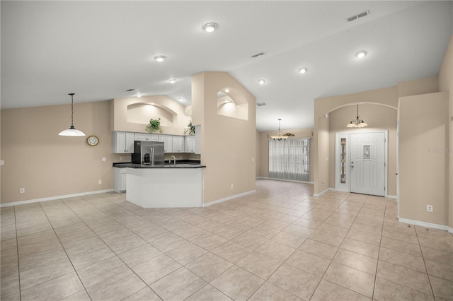 interior space featuring a chandelier, light tile patterned floors, and high vaulted ceiling