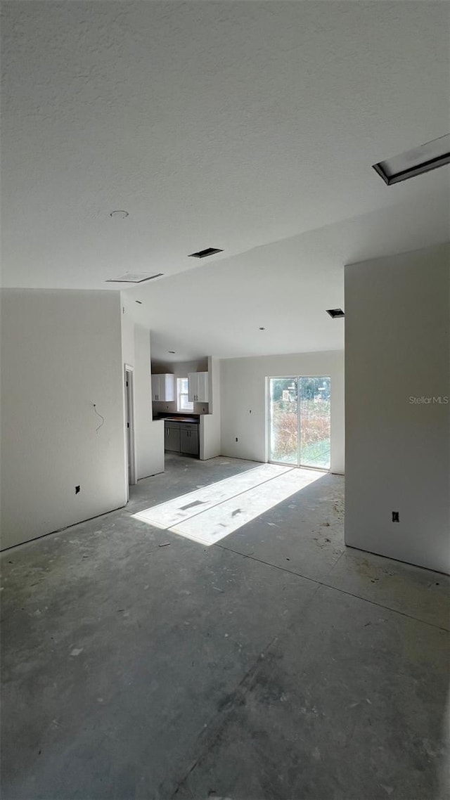 unfurnished living room with concrete floors