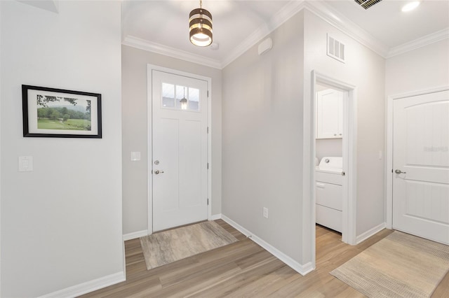 entryway with light hardwood / wood-style flooring, crown molding, and washer / clothes dryer