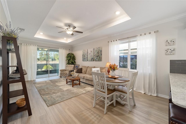 dining room featuring a raised ceiling, ceiling fan, ornamental molding, and hardwood / wood-style floors