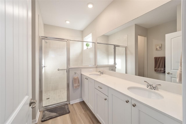 bathroom featuring wood-type flooring, an enclosed shower, and vanity