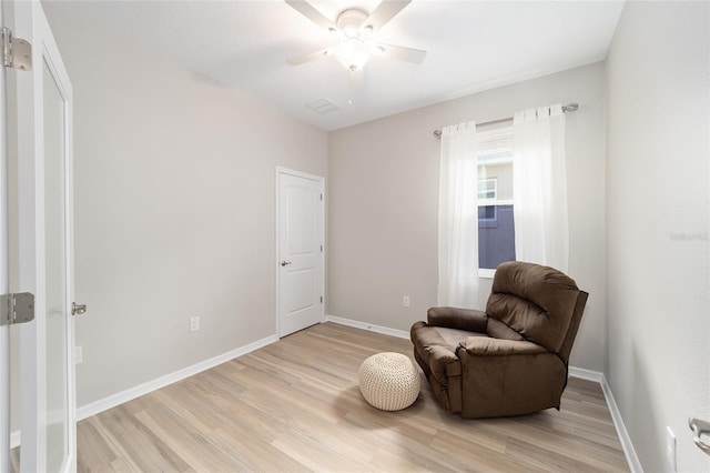 living area with ceiling fan and light hardwood / wood-style flooring