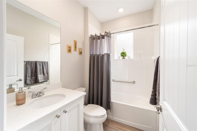 full bathroom with toilet, vanity, hardwood / wood-style flooring, and shower / bathtub combination with curtain