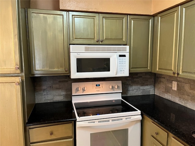 kitchen featuring white appliances, dark stone counters, and decorative backsplash