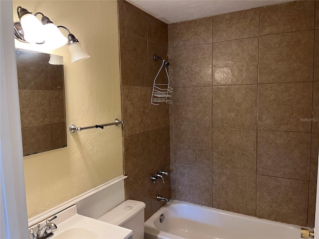 bathroom with tiled shower / bath and toilet