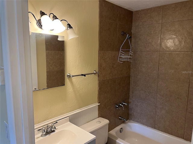 full bathroom with vanity, tiled shower / bath combo, and toilet