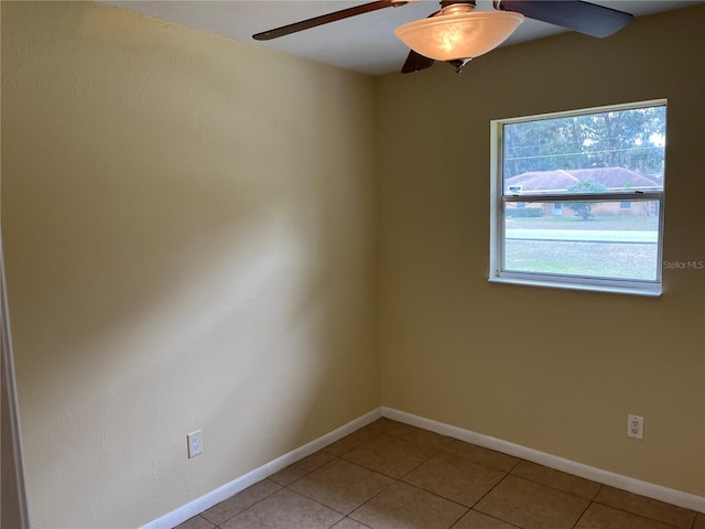 tiled spare room featuring a wealth of natural light and ceiling fan