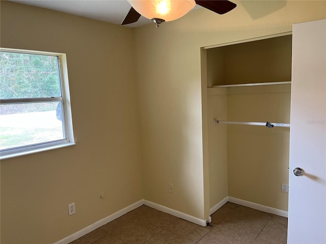 unfurnished bedroom with light tile patterned flooring, ceiling fan, a closet, and multiple windows