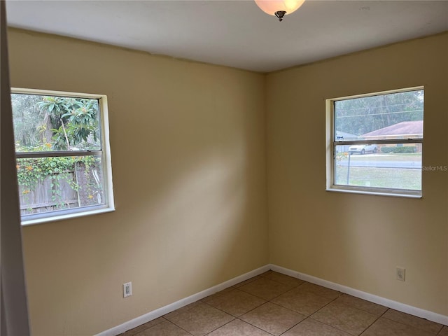 tiled spare room with a healthy amount of sunlight