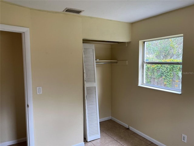 unfurnished bedroom with a closet and light tile patterned floors