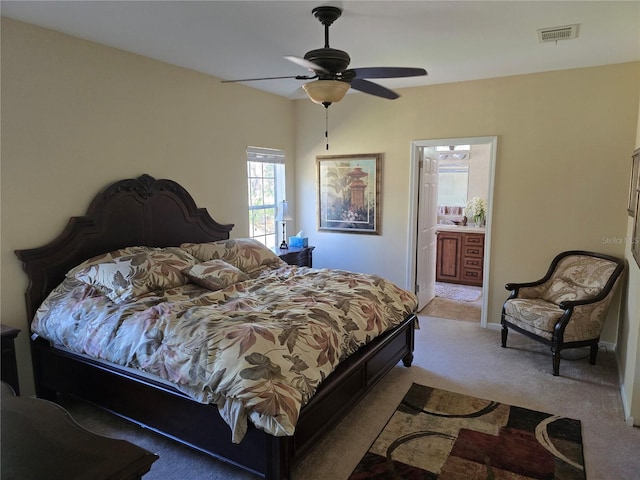 carpeted bedroom with ceiling fan and ensuite bath