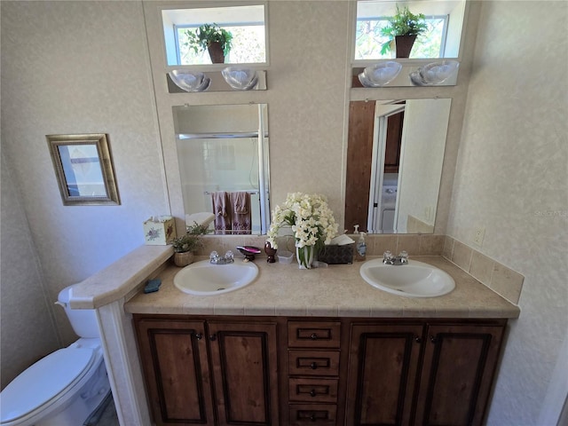 bathroom featuring a wealth of natural light, vanity, and toilet