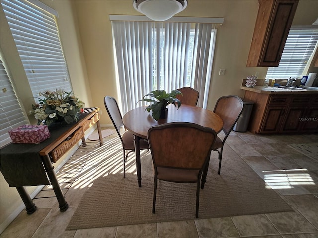 dining space with light tile patterned floors and sink