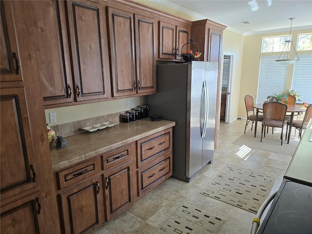 kitchen with stainless steel fridge, pendant lighting, electric range oven, and crown molding