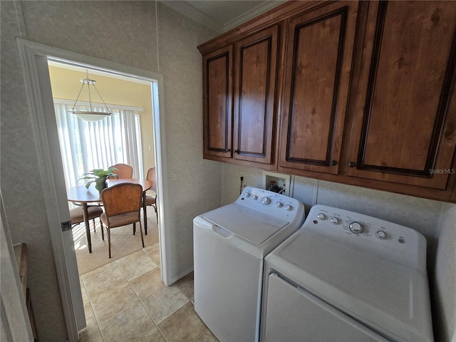 clothes washing area with separate washer and dryer, light tile patterned flooring, cabinets, and ornamental molding