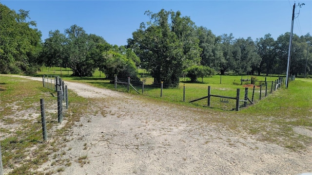 view of property's community with a rural view and a lawn